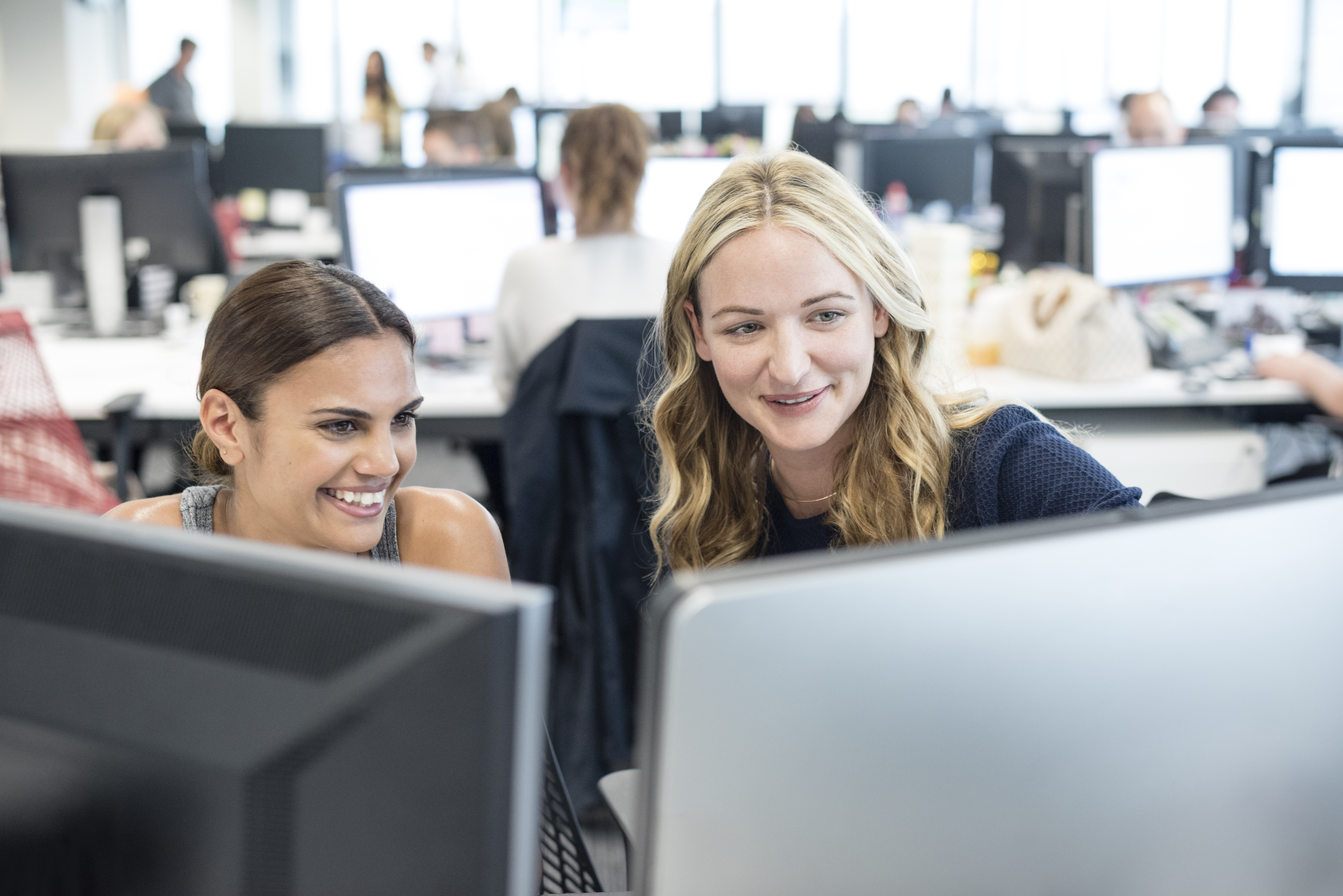 2 ladies looking at screens